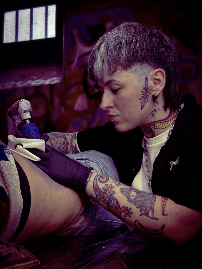 a tattoo artist artfully applies a tattoo